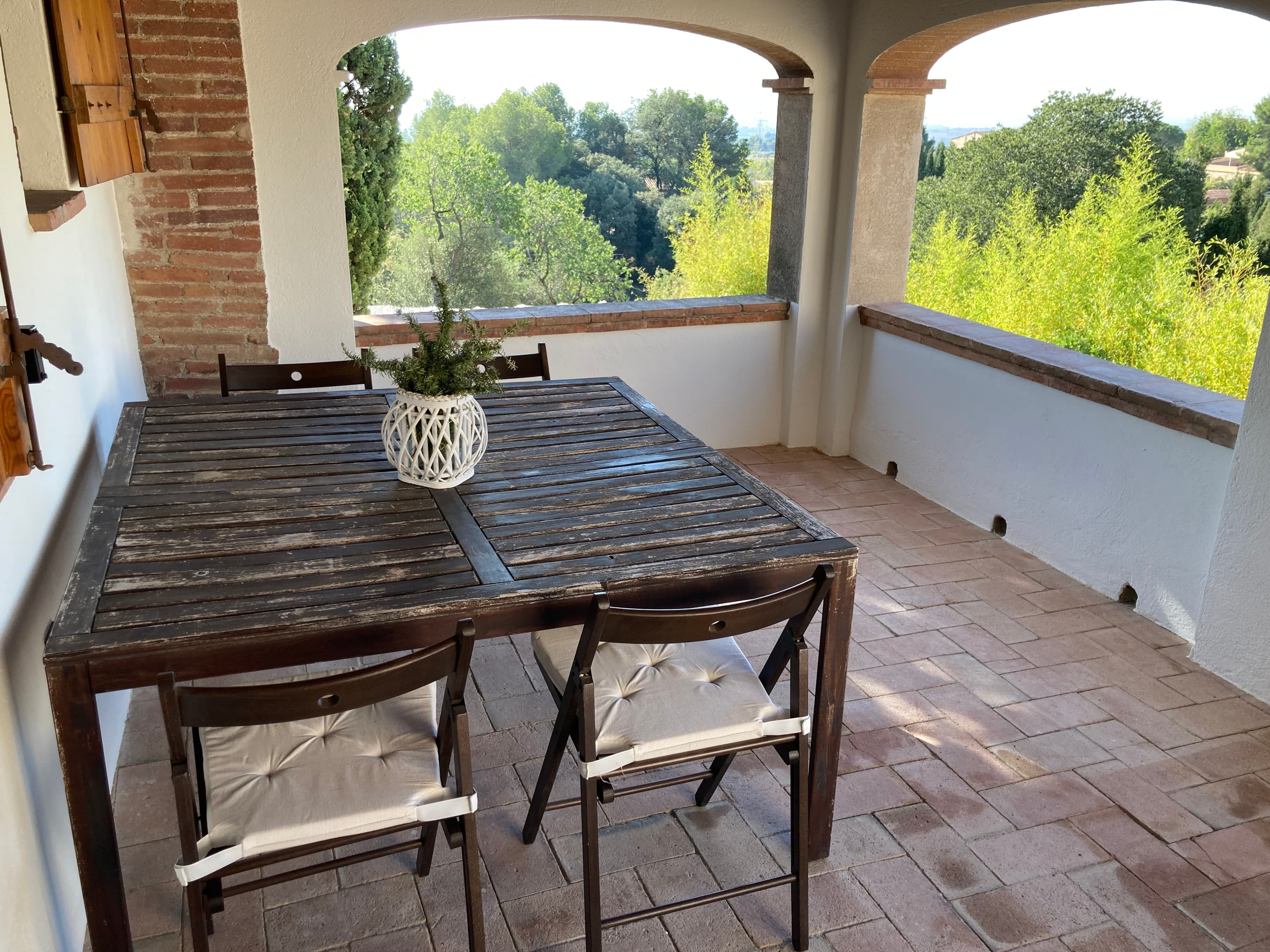 Porxo de l’Habitació Suite amb taula i cadires de fusta i vistes al camp