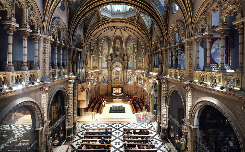 nterior de la Abadia de Montserrat amb arquitectura detallada i una vista completa de la nau central.